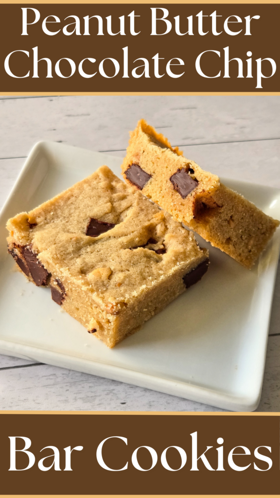 Two square-cut, golden cookie bars dotted with chocolate chunks, rest on a square white plate, one propped against the other to show a side view of the bar.